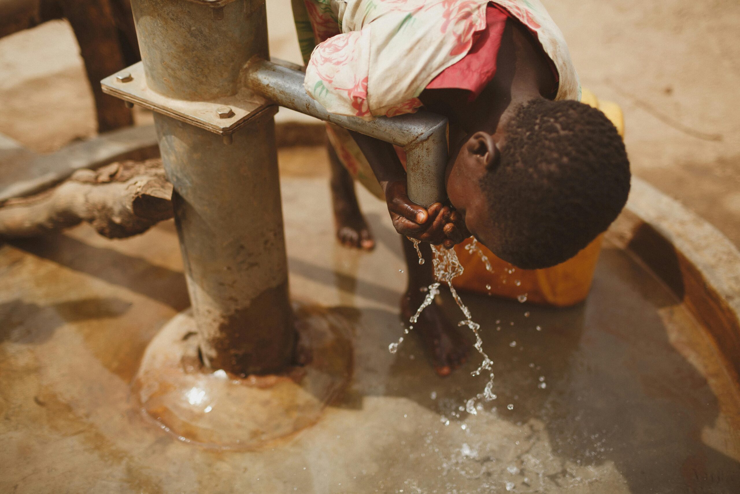 A girl bends to drink clean water from a well in central-Somalia.